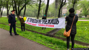 "Асия Тулесова и Бейбарыс Толымбеков с баннером. Алматы, 21 апреля 2019 года.